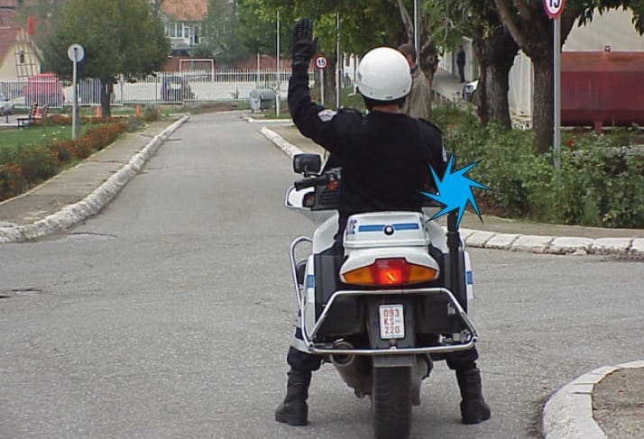 What does the raised hand of the policeman mean?