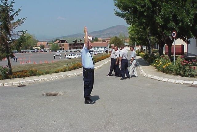 What does the raised hand of the policeman as in the picture mean.